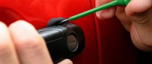 Eine Autotür wird mit Hilfe eines Schraubenziehers geöffnet.