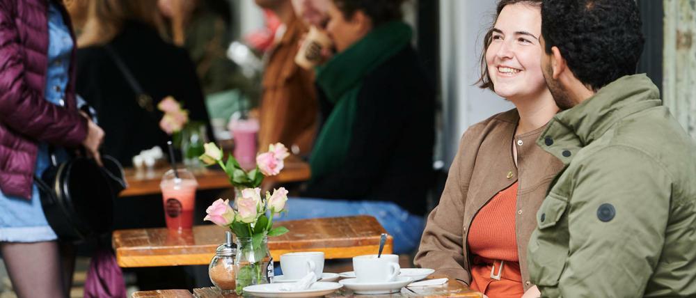 Menschen im Straßencafé am Weinbergsweg in Berlin-Mitte.