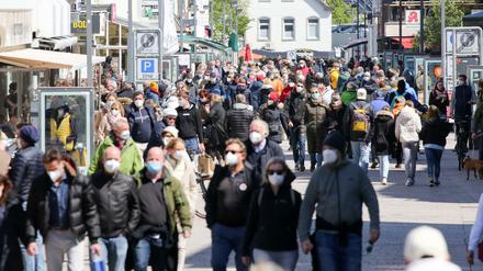 Besucher sind bei Sonnenschein in der Innenstadt von Westerland unterwegs. 