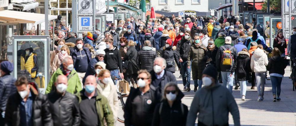 Besucher sind bei Sonnenschein in der Innenstadt von Westerland unterwegs. 