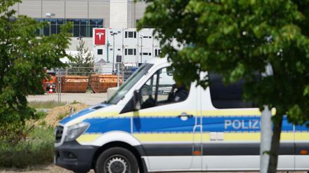 Ein Polizeiauto steht in Sichtweite der Tesla-Baustelle bei Grünheide.
