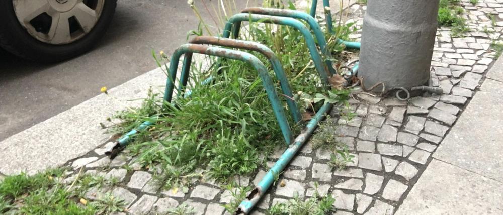 Verrosteter, grün gefärbter, altmodischer Fahrradständer am Straßenrand in Berlin-Wilmersdorf.