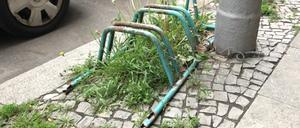 Verrosteter, grün gefärbter, altmodischer Fahrradständer am Straßenrand in Berlin-Wilmersdorf.