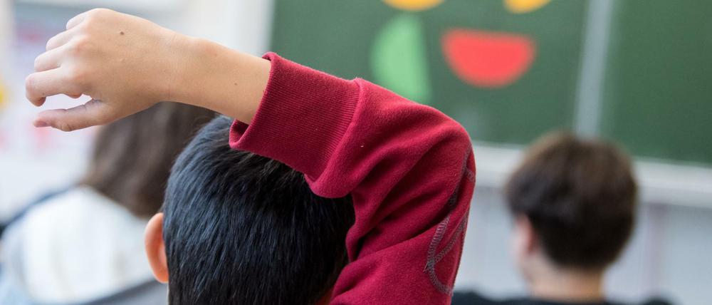 Ein Schüler meldet sich während einer Mathestunde im Präsenzunterricht. In Berlin sollen die Schüler erst nach den Ferien vollständig in die Klassen zurückkehren.