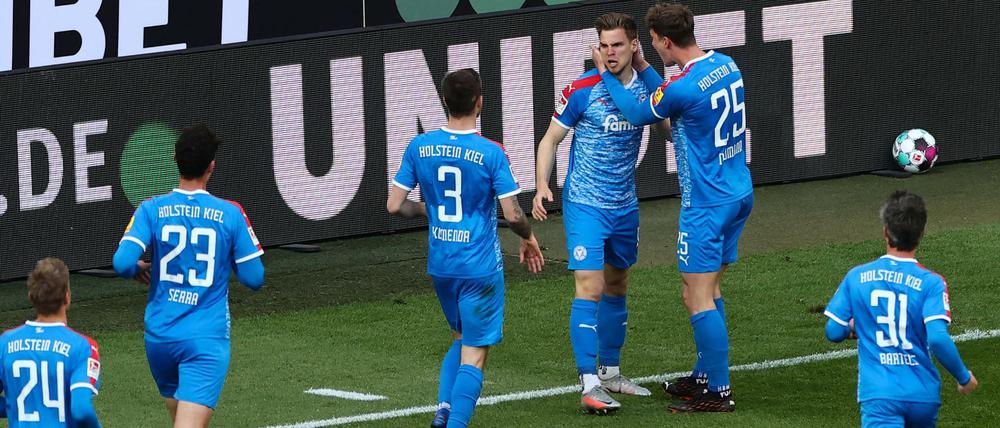 Kiels Abwehrspieler Simon Lorenz feiert mit seinen Mannschaftskameraden das 1:0.