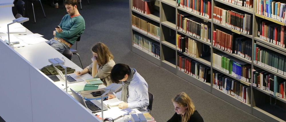 Studierende arbeiten in einer Unibibliothek.