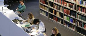 Studierende arbeiten in einer Unibibliothek.