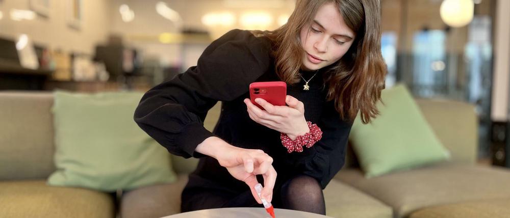 Freetogo Mitgründerin Pia Junghans (18) demonstriert, wie man den Selbsttest mit dem Handy dokumentiert.