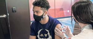 An einer US-Universität wird ein Student von einer Ärztin geimpft.