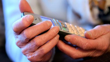 Eine Frau hält ein Telefon in der Hand.