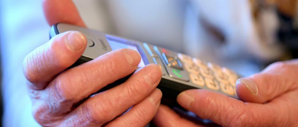 Eine Frau hält ein Telefon in der Hand.