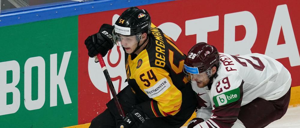 Deutschlands Lean Bergmann (l) und Lettlands Ralfs Freibergs (r) kämpfen um den Puck.