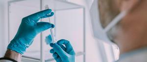 Ein Arzt befüllt eine Spritze mit Corona-Impfstoff (Symbolfoto)