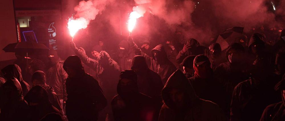 Vermummte Demonstranten bei einem Protestzug.