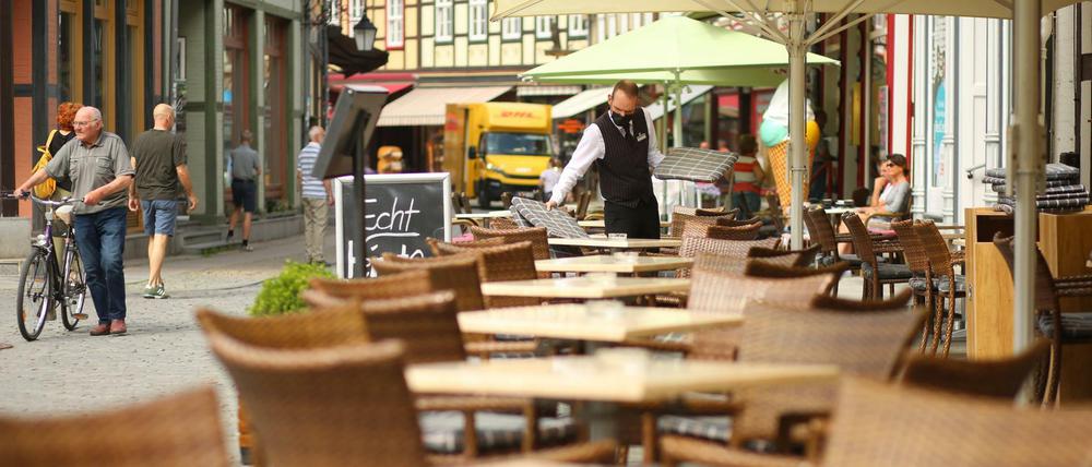 Ein Kellner deckt in Wernigerode, Sachsen-Anhalt, die Tische des Außenbereichs. 