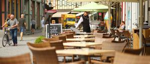 Ein Kellner deckt in Wernigerode, Sachsen-Anhalt, die Tische des Außenbereichs. 