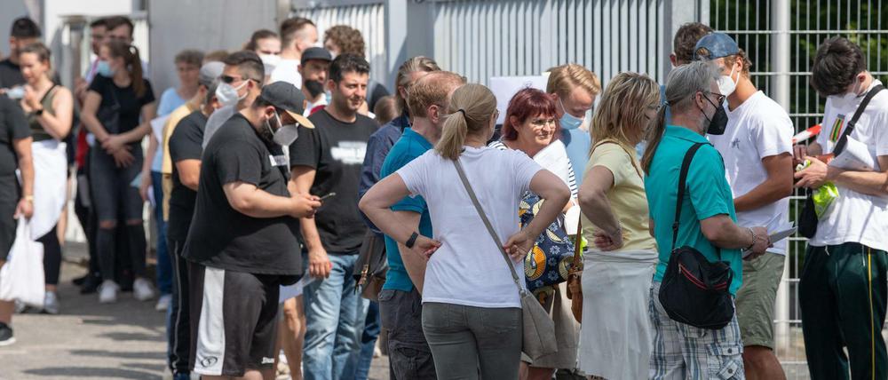 Mehr als 1500 Menschen warten bei sommerlichen Temperaturen im Freien auf Einlass in eine Arztpraxis im hessischen Babenhausen.