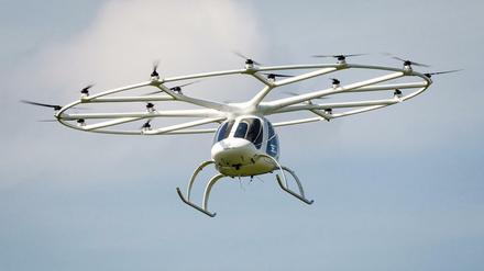 Ein Volocopter fliegt in einer europäischen Stadt.