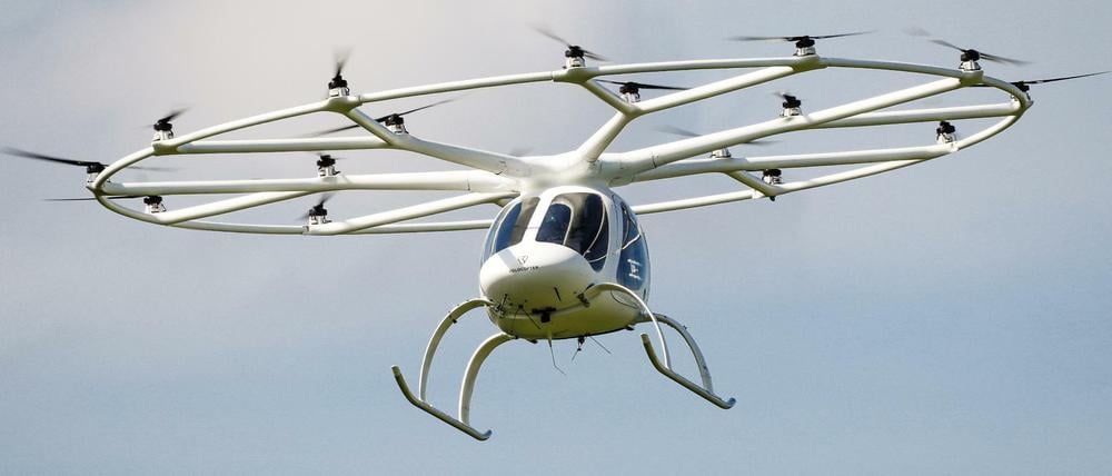 Ein Volocopter fliegt in einer europäischen Stadt.