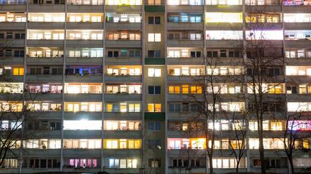 In einem Hochhaus in Berlin sind einige Fenster beleuchtet.