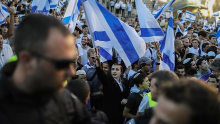 Menschen schwenken bei dem von rechtsgerichteten Nationalisten in Israel organisierten Flaggenmarsch Nationalflaggen.