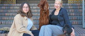 Pfarrerin Claudia Wüstenhagen und ihre Tochter Nora mit Irish Setter Grace und Zwergpudel Cherry auf den Kirchenstufen am Hohenzollernplatz in Berlin-Wilmersdorf.