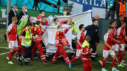 Der Spieler Christian Eriksen wird vom Platz getragen.