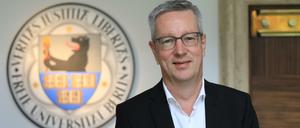Ein Porträtbild von Günter M. Ziegler vor dem Wappen der Freien Universität.