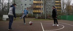 Kinder spielen vor der Arche Fussball. 