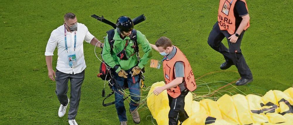 Der Pilot des Gleitfliegers wird nach seiner Aktion kurz vor dem Anpfiff der Partie Frankreich-Deutschland vom Feld geführt.