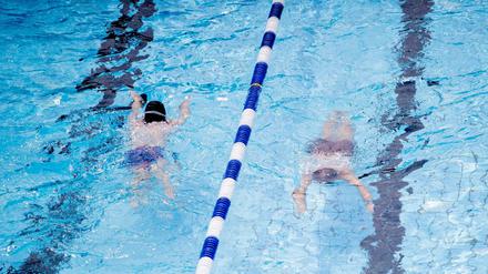 Zwei junge Badegäste schwimmen im Sommerbad Humboldthain. Kinder bis 12 Jahren erhalten in den Sommerferien freien Eintritt - allerdings nur begrenzt.