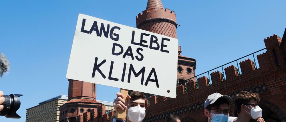 "Lang lebe das Klima"· steht auf dem Transparent eines Demonstranten, der mit vielen weiteren Klimaschützern über die Oberbaumbrücke geht.