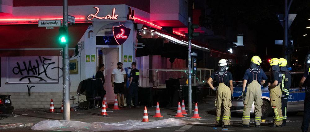 Feuerwehrleute stehen vor dem Lokal in der Müllerstraße. 