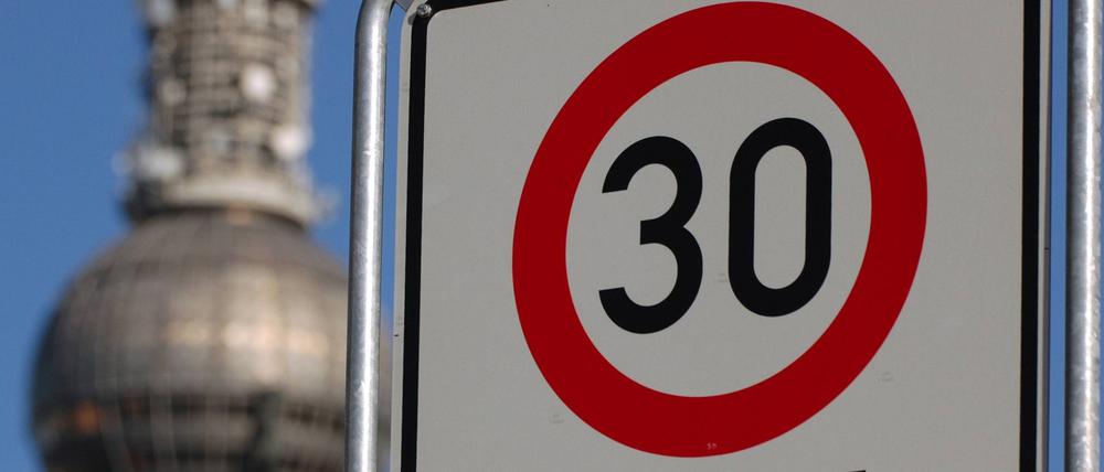 Tempo 30-Straßenschild vor dem Fernsehturm in Berlin.