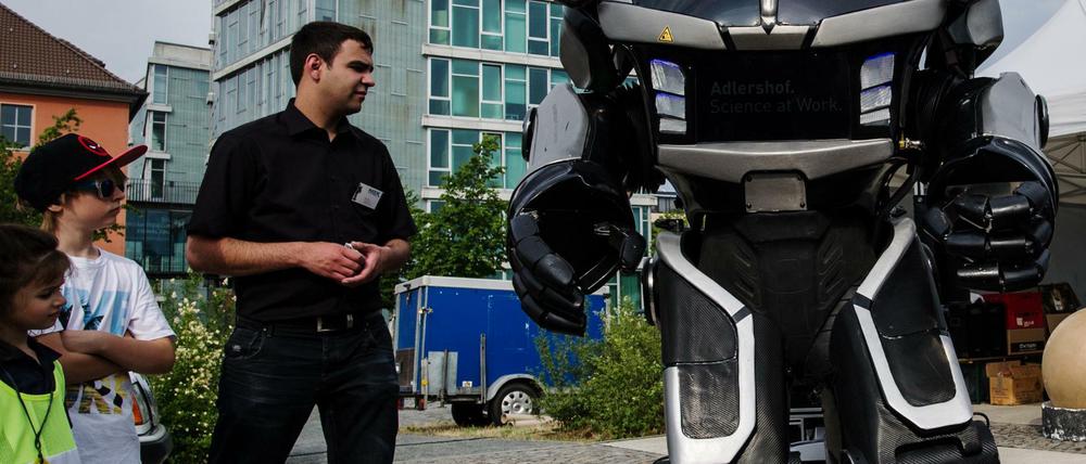 Ein Roboter begrüßt junge Besucher:innen der Langen Nacht der Wissenschaften.