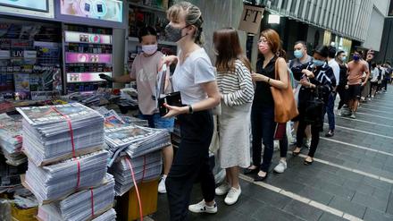 Hongkongs Einwohner:innen stehen Schlange, um das letzte Exemplar von "Apple Daily" zu kaufen.