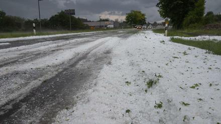 Hagelkörner liegen in der Ortsdurchfahrt in Kirchheim/Teck. Die Feuerwehren sind derzeit im Dauereinsatz.