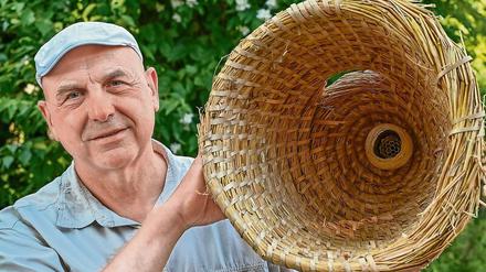 Holger Ackermann, Imker und Sprecher des Landes-Imkerverbands Brandenburg, zeigt in einer Bienenbeute ein Nest einer Hornissenkönigin. 