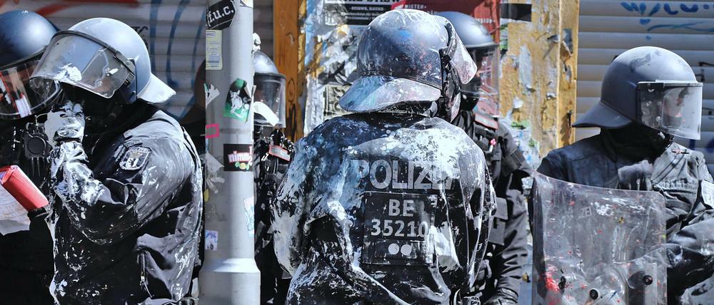 Mit Farbbeuteln beworfene Polizei stehen vor der teilbesetzten Rigaer Strasse 94.