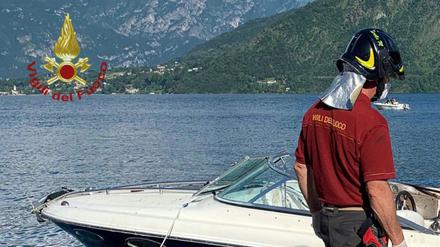 Ein Feuerwehrmann steht neben einem Motorboot, das auf dem Comer See mit einem anderen Motorboot zusammengestoßen war.