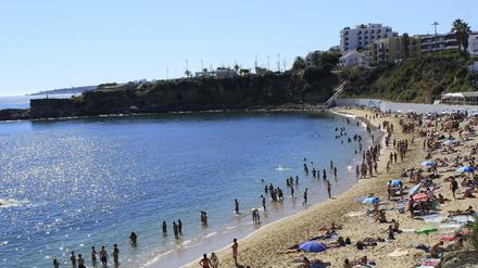 Badegäste am Strand von Sao Pedro do Estoril in Portugal.