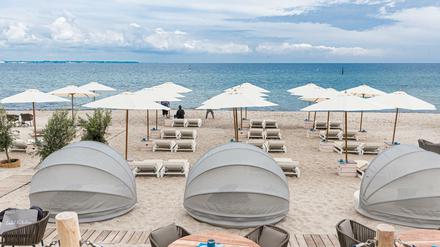 Strandliegen und Sonnenschirme stehen in Timmendorfer-Strand für Badegäste bereit.