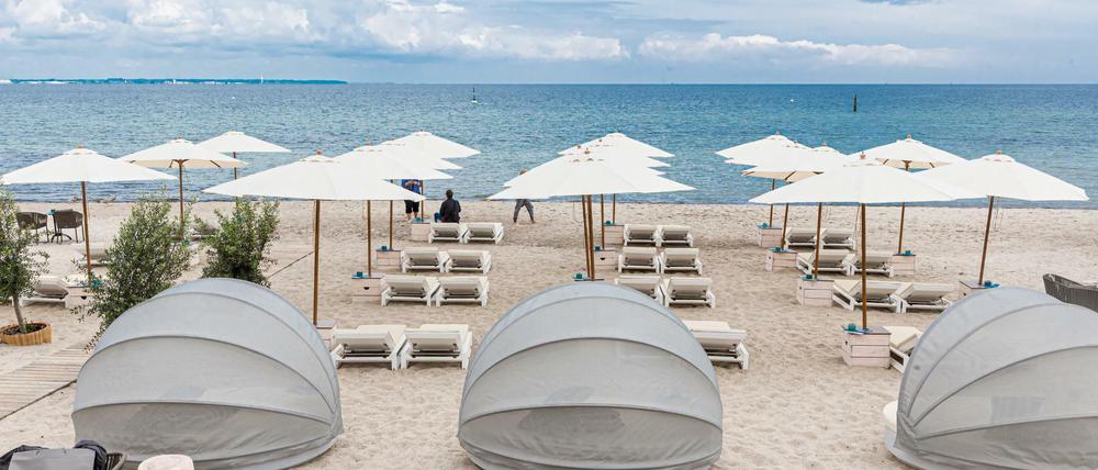 Strandliegen und Sonnenschirme stehen in Timmendorfer-Strand für Badegäste bereit.