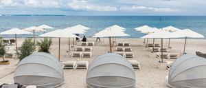 Strandliegen und Sonnenschirme stehen in Timmendorfer-Strand für Badegäste bereit.