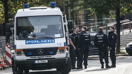 Polizisten stehen neben ihrem Einsatzwagen. (Symbolbild)