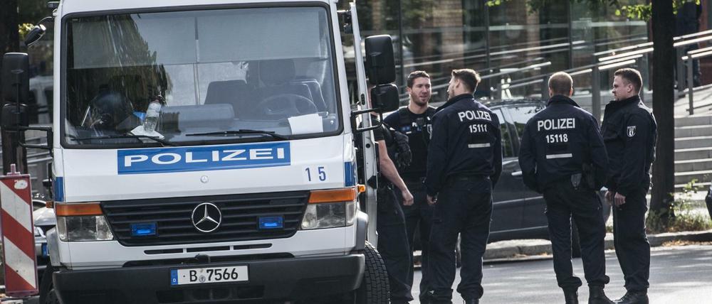 Polizisten stehen neben ihrem Einsatzwagen. (Symbolbild)