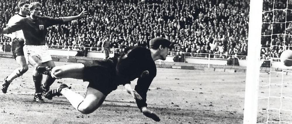 Der deutsche Torwart Hans Tilkowski ist beim Schuss von Geoff Hurst geschlagen. Von der Unterkante der Latte prallt der Ball aber vor der Linie auf den Rasen.