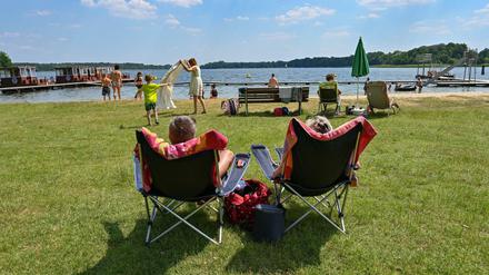 Badegäste genießen das sonnige und warme Wetter am Strandbad Storkow am Storkower See. 
