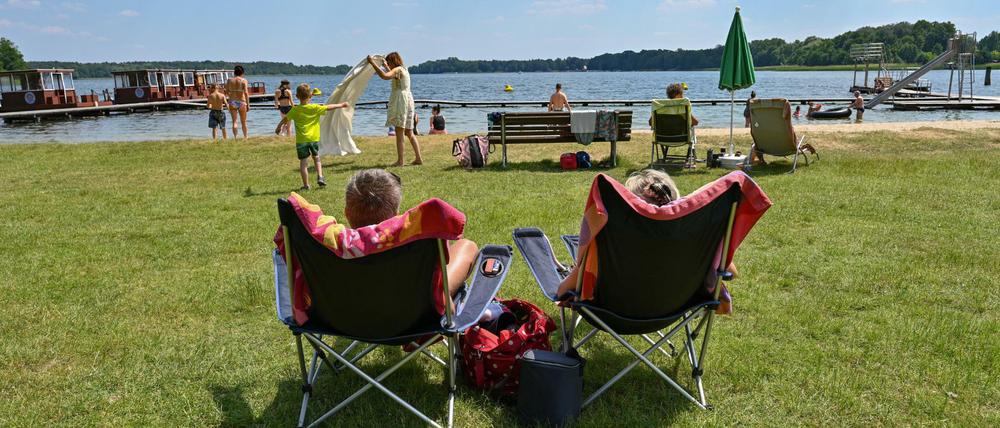 Badegäste genießen das sonnige und warme Wetter am Strandbad Storkow am Storkower See.