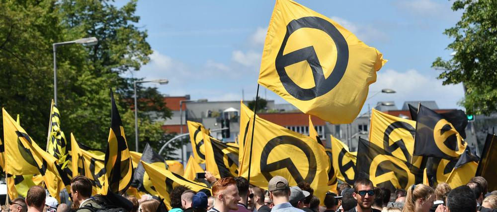 Anhänger der rechtsradikalen "Identitären Bewegung" stehen mit Fahnen auf der Brunnenstraße.